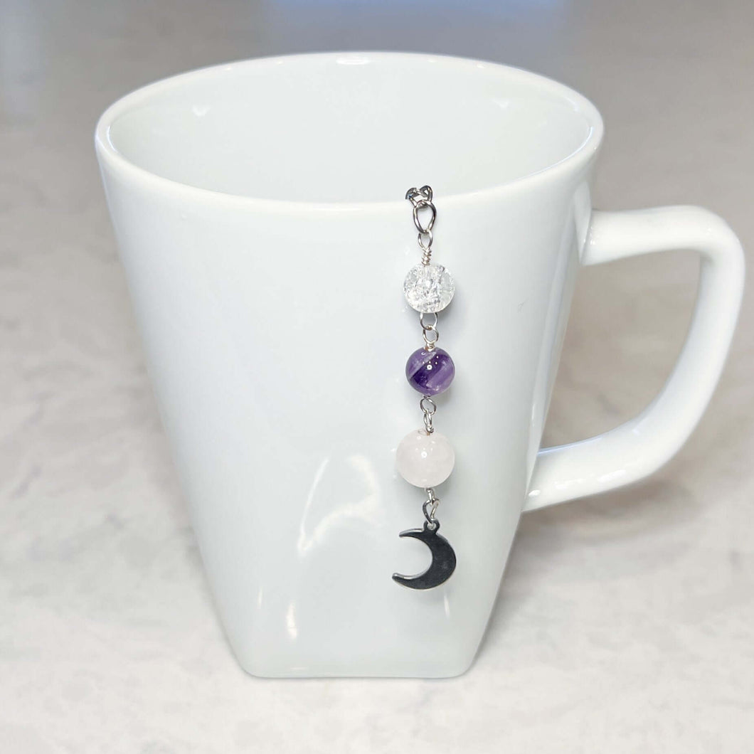 Amethyst and Quartz Tea Strainer This tea strainer is made with a stainless steel tea ball, Rose Quartz, Crystal Crackle Quartz, and Amethyst beads. These stones together bring the user mental clarity and universal love.