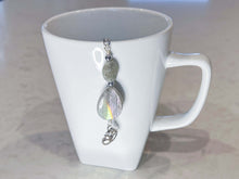 Load image into Gallery viewer, Labradorite Tea Strainer This tea strainer is made with a stainless steel tea ball, Labradorite and Hematite stones with a lotus flower charm. These stones bring the user protection and encourages spiritual transformation.
