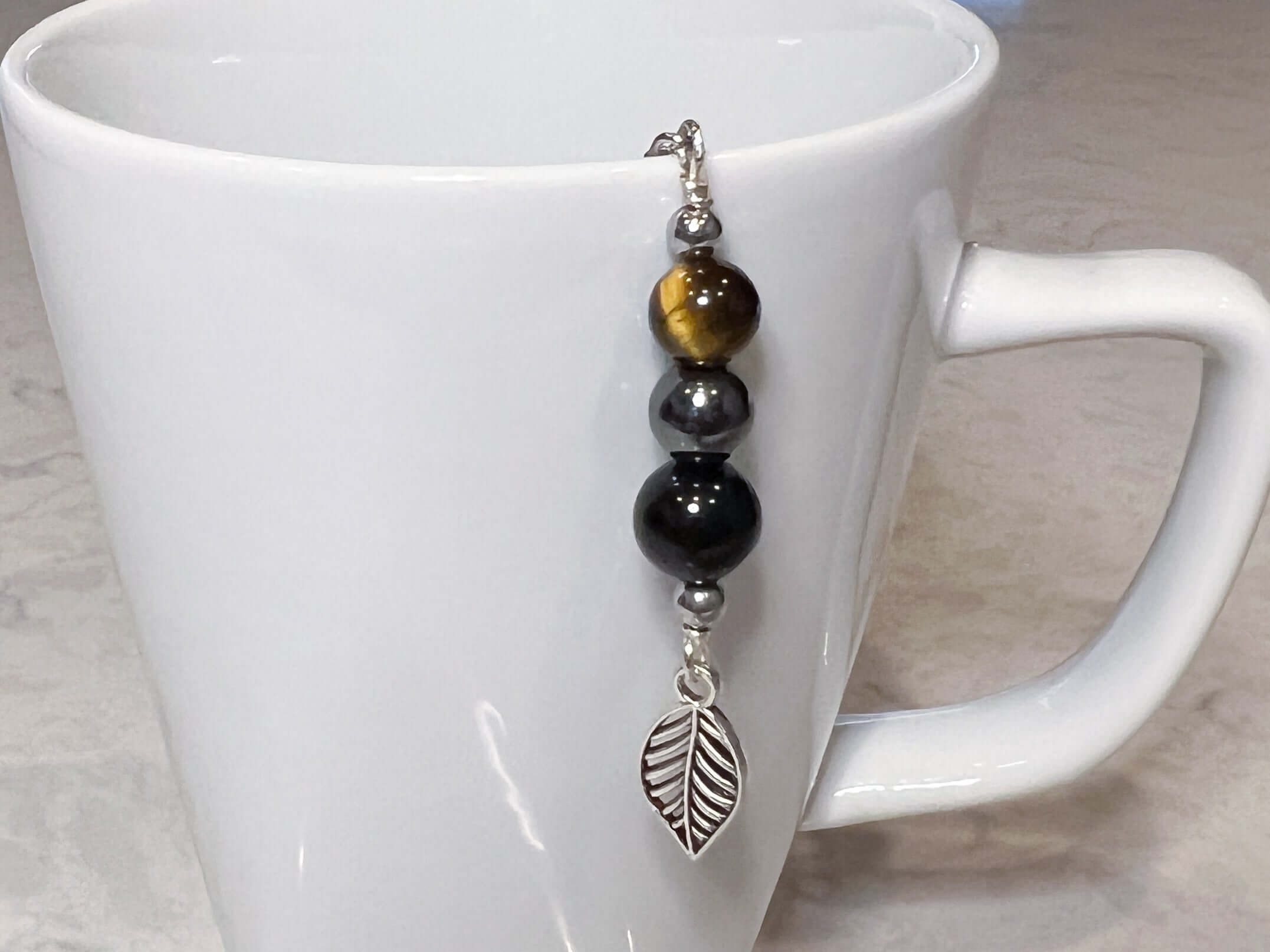 Triple Protection Tea Strainer This tea strainer is made with a stainless steel tea ball and gold sheen obsidian, hematite, and tiger eye. These stones offer protection against negative energy of all kinds- inner, spiritual, and environmental.