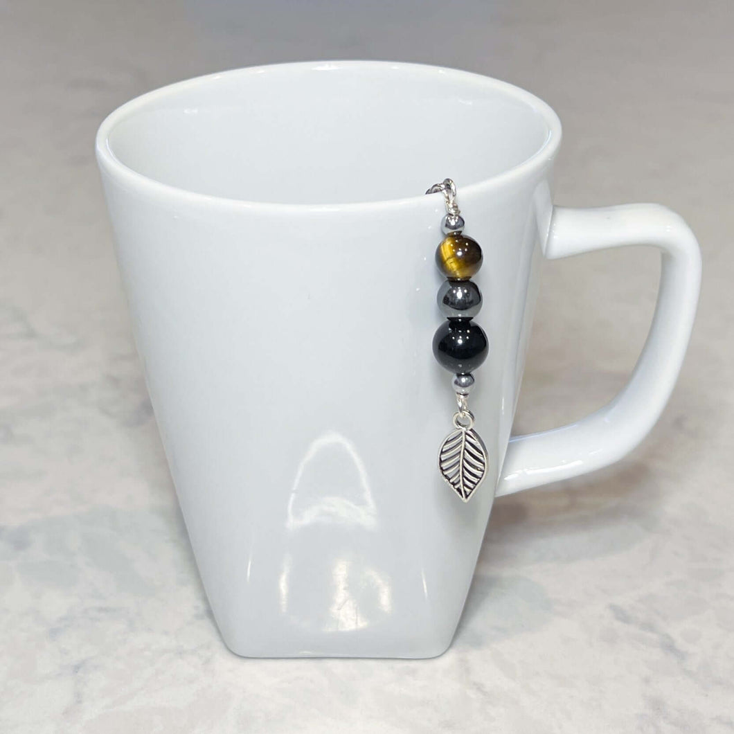 Triple Protection Tea Strainer This tea strainer is made with a stainless steel tea ball and gold sheen obsidian, hematite, and tiger eye. These stones offer protection against negative energy of all kinds- inner, spiritual, and environmental.