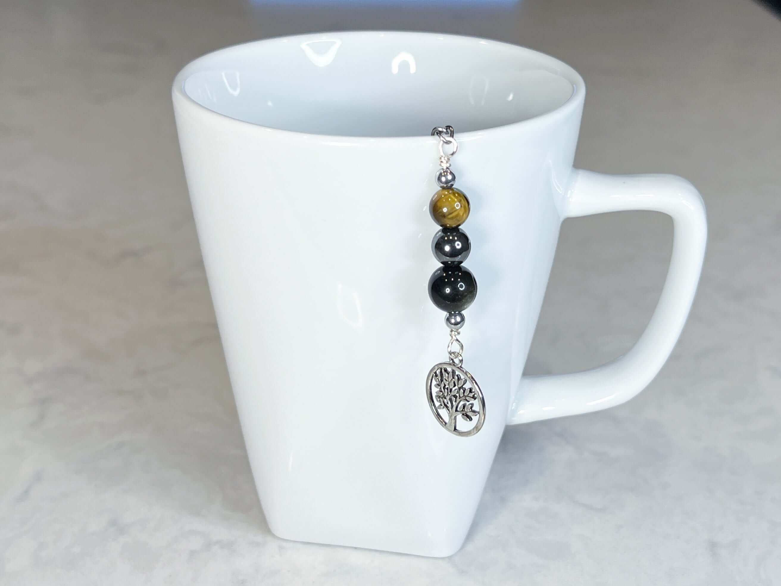 Triple Protection Tea Strainer This tea strainer is made with a stainless steel tea ball and gold sheen obsidian, hematite, and tiger eye. These stones offer protection against negative energy of all kinds- inner, spiritual, and environmental.