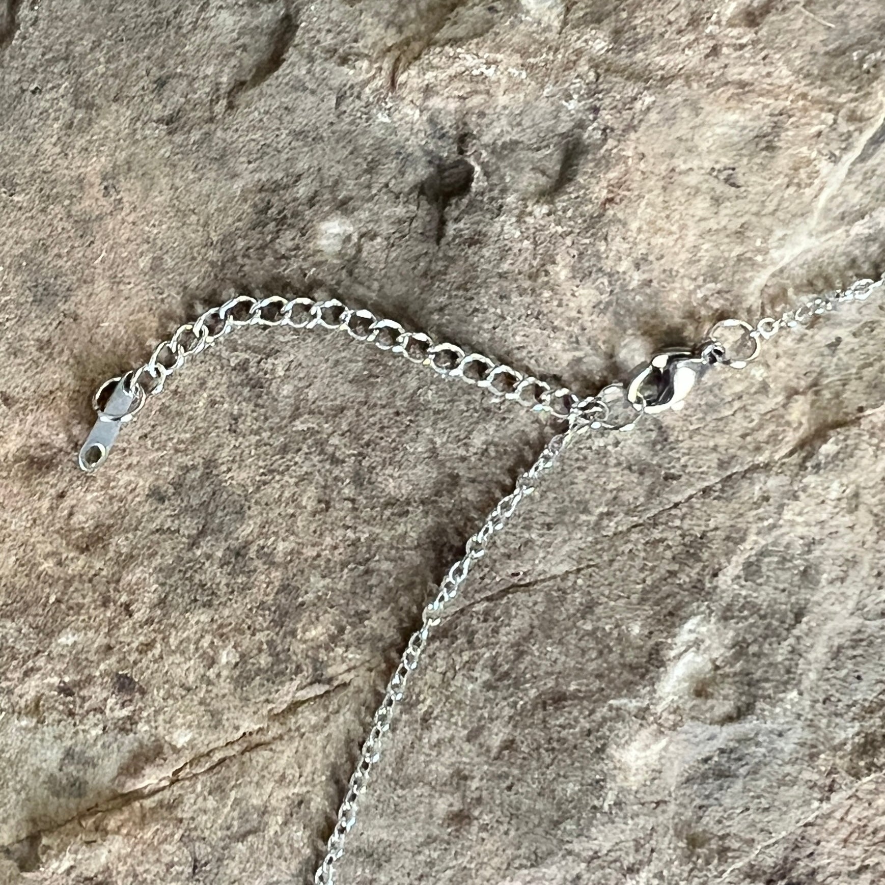 close up of stainless steel cable chain, lobster clasp, and 2" extender