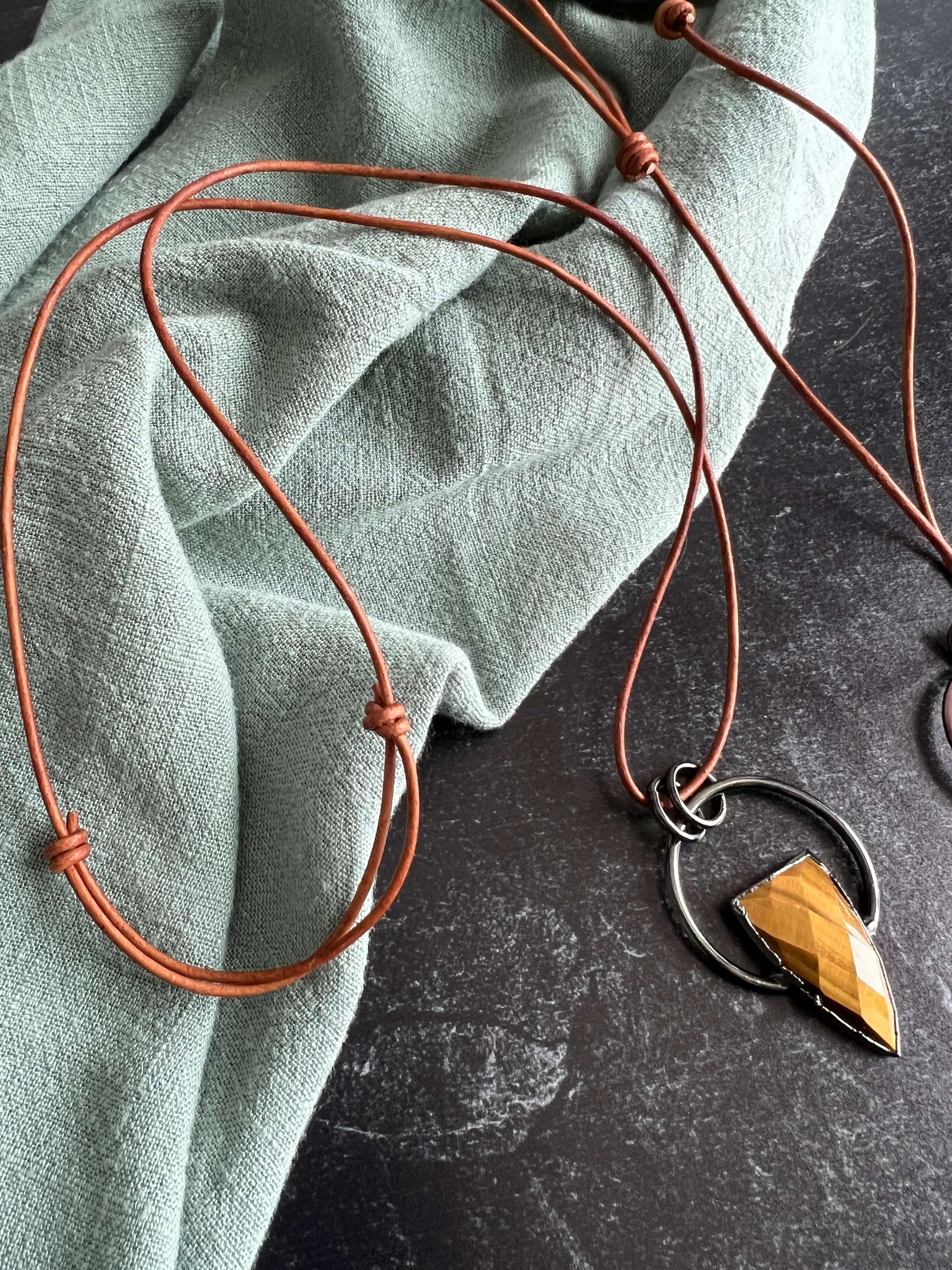 Tiger Eye Pendant Slide Knot Necklace This necklace is made with high-quality Tiger Eye gemstones which bring clarity and grounding energy to the wearer. Zodiac Signs: Leo and Capricorn. Chakras: Sacral, Solar Plexus, and Third Eye. Handmade with authenti