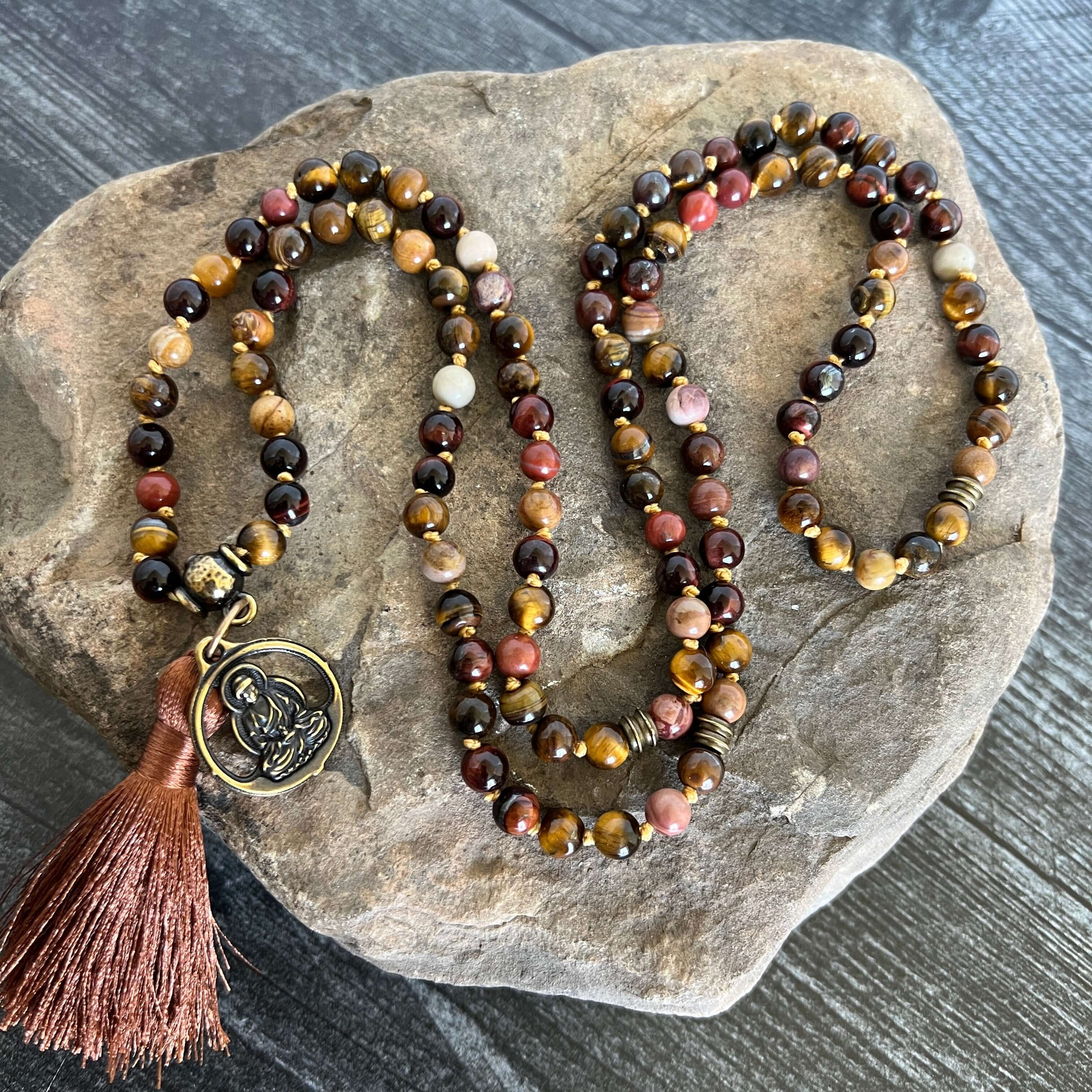 Tiger Eye Mala This mala is made with brown Tiger Eye, Red Tiger Eye, and Mookaite stones which bring a stable, grounding energy to the wearer. Due to the uniqueness of natural stone, your mala may look slightly different than the one pictured. Making you