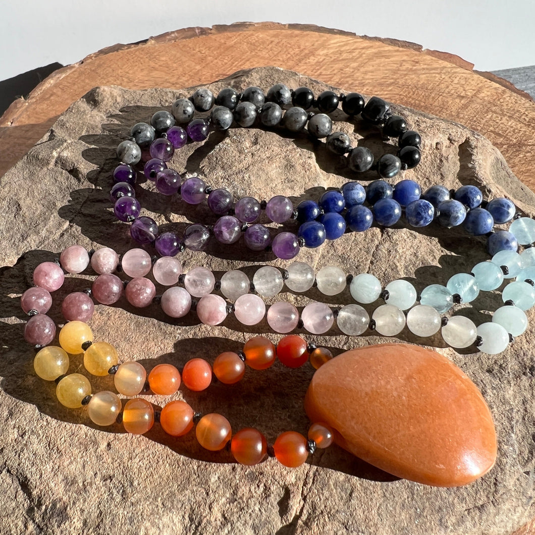 Sunset Mala This mala is made with authentic Carnelian, Yellow Jade, Lepidolite, Moonstone, Aquamarine, Sodalite, Amethyst, Larvikite, Red Aventurine, and Onyx gemstones which give the wearer a sense of being deeply rooted. Zodiac Signs: All. Chakras: All