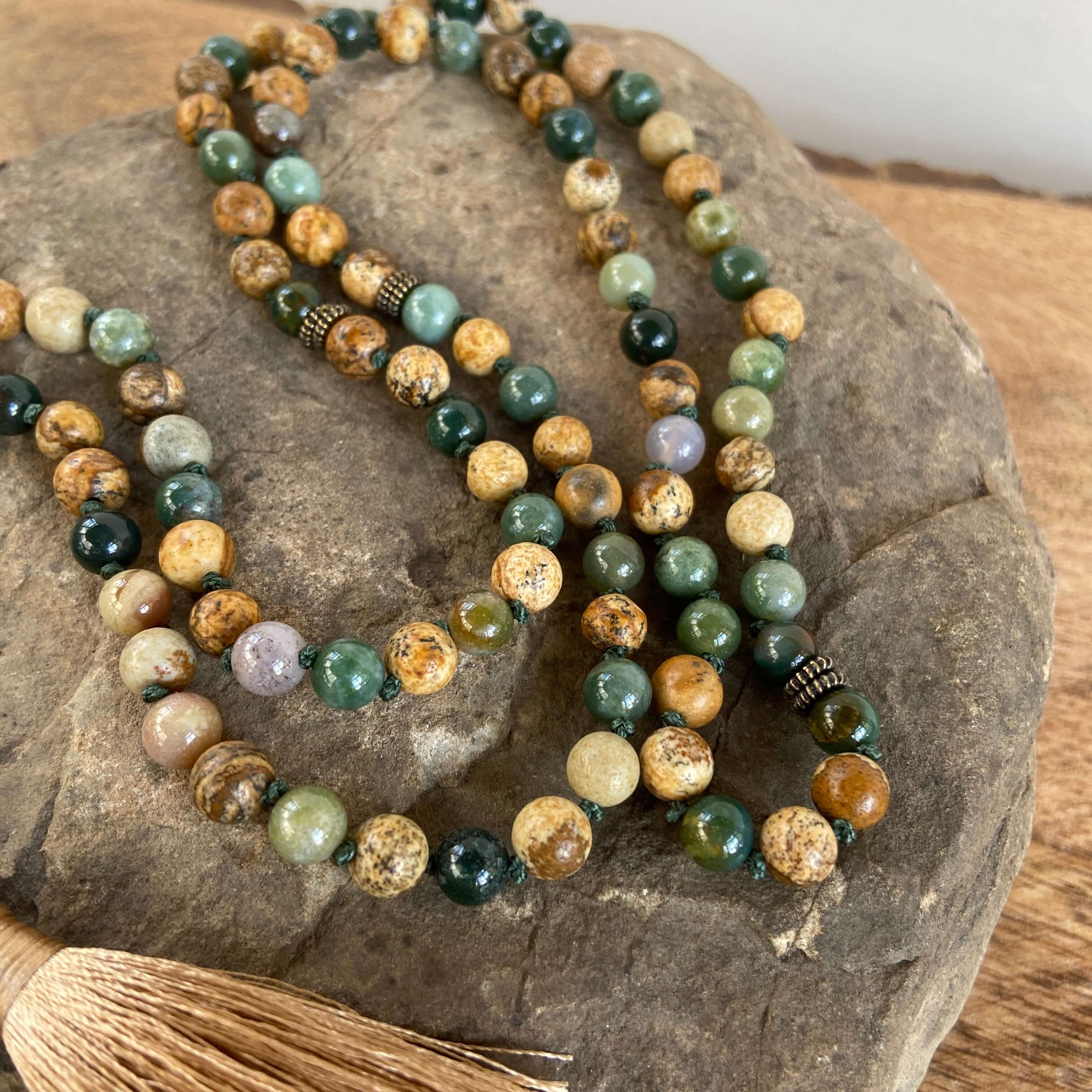 Tree Mala While creating these malas, I kept imaging the look of trees along the north shore of Lake Superior. It is made with 6mm sized Moss Agate and Picture Jasper stones, along with a Picture Jasper guru bead carved to look like a leaf. and brown silk