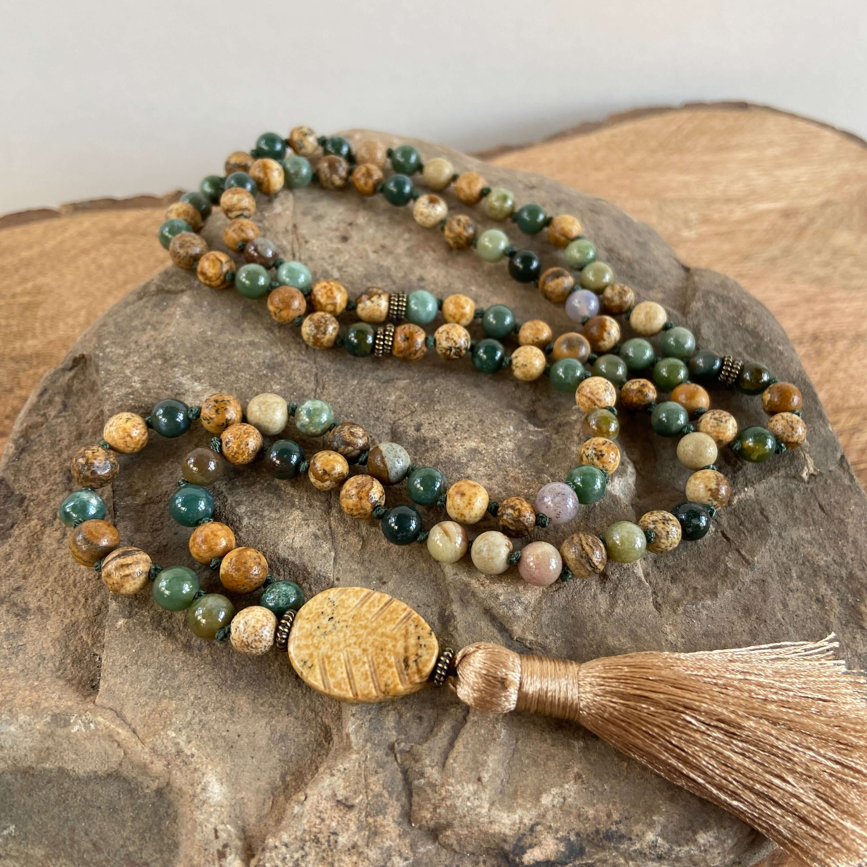 Tree Mala While creating these malas, I kept imaging the look of trees along the north shore of Lake Superior. It is made with 6mm sized Moss Agate and Picture Jasper stones, along with a Picture Jasper guru bead carved to look like a leaf. and brown silk