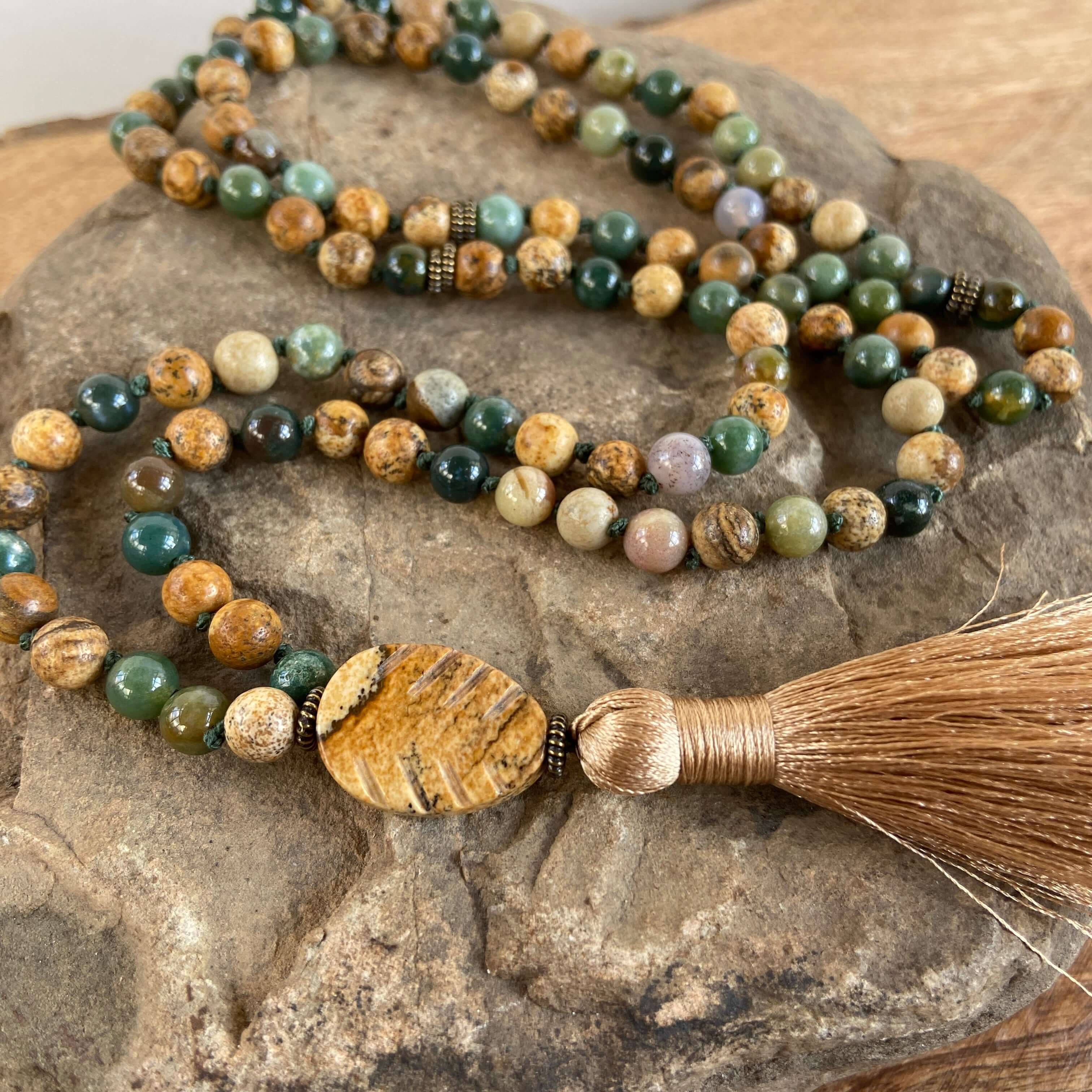 Tree Mala While creating these malas, I kept imaging the look of trees along the north shore of Lake Superior. It is made with 6mm sized Moss Agate and Picture Jasper stones, along with a Picture Jasper guru bead carved to look like a leaf. and brown silk